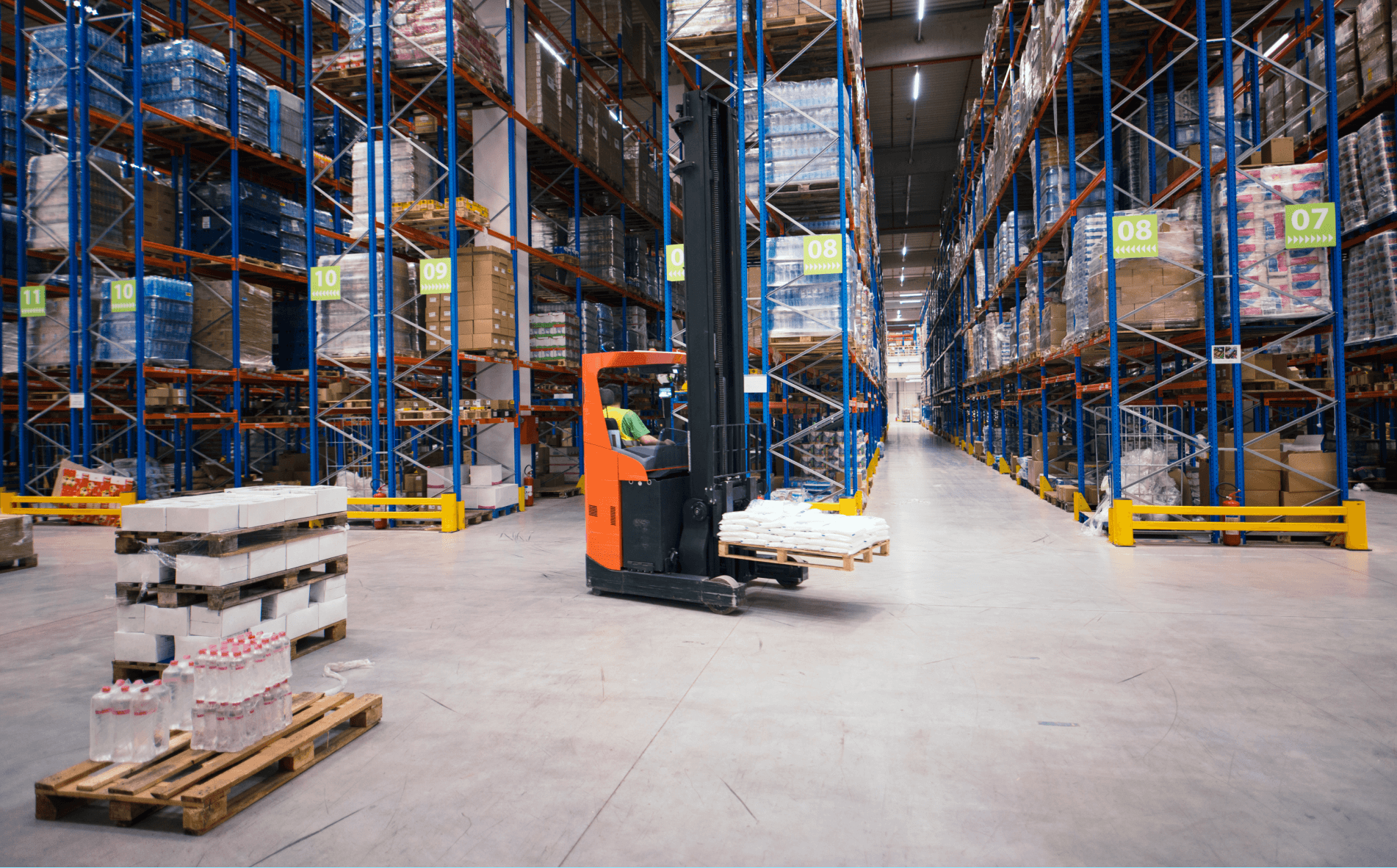 Warehouse storage with automation forklift handling pallets of goods in a distribution centre.