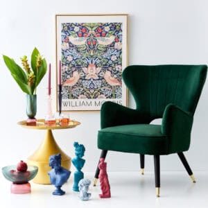 a green chair and vase of flowers and a framed picture