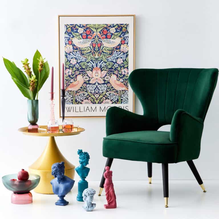 a green chair and vase of flowers and a framed picture